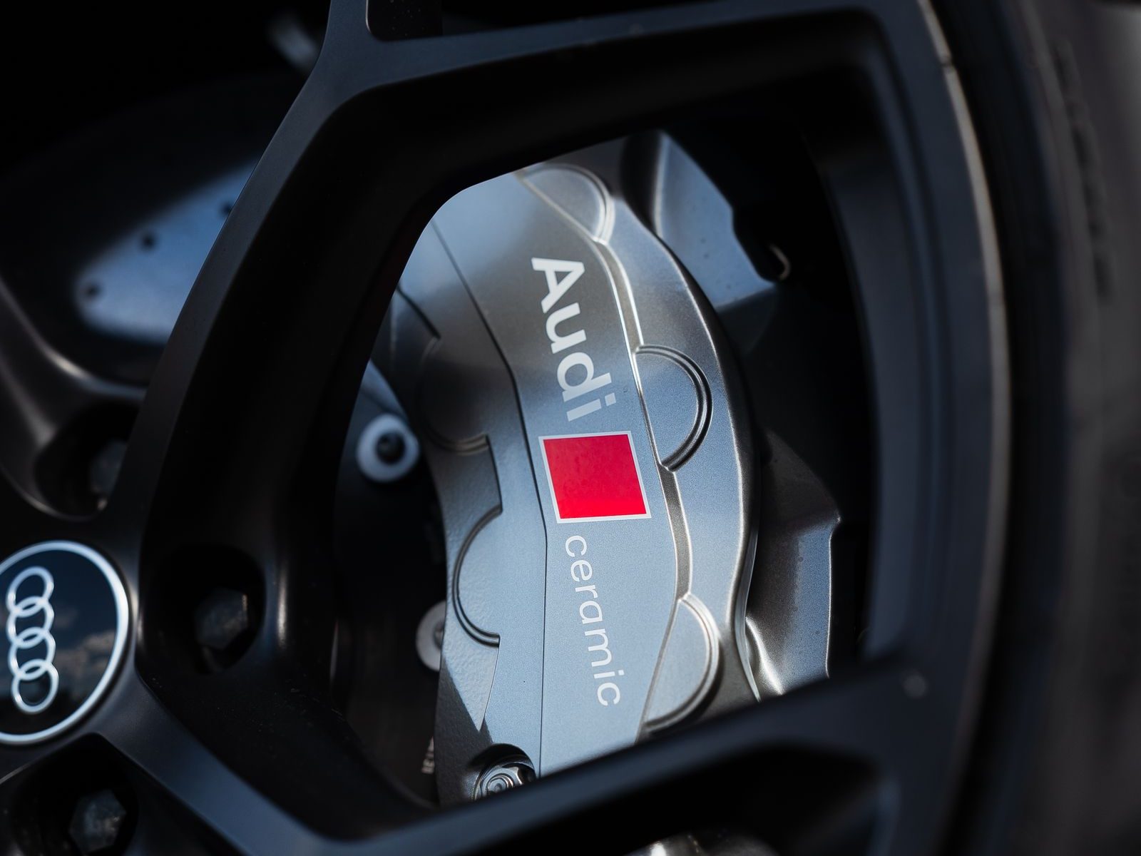 Audi carbon-ceramic brake caliper and rotor behind an alloy wheel